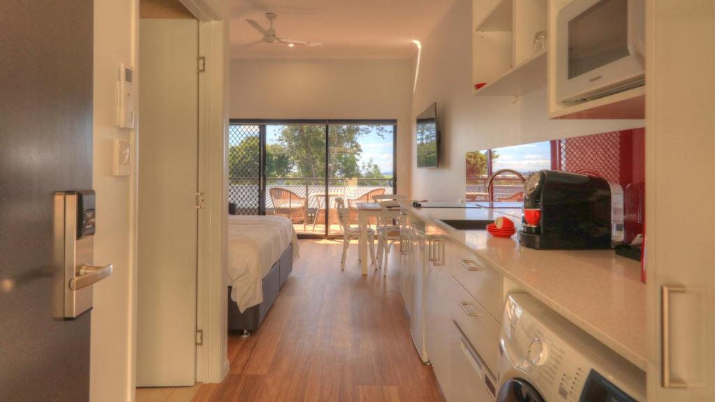 a room with a bed and a kitchen with a view at Atherton Apartments in Atherton