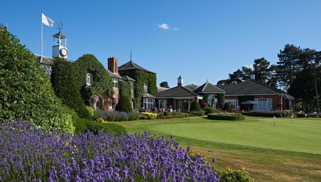 une maison avec des fleurs violettes devant une cour dans l'établissement The Belfry Hotel & Resort, à Sutton Coldfield