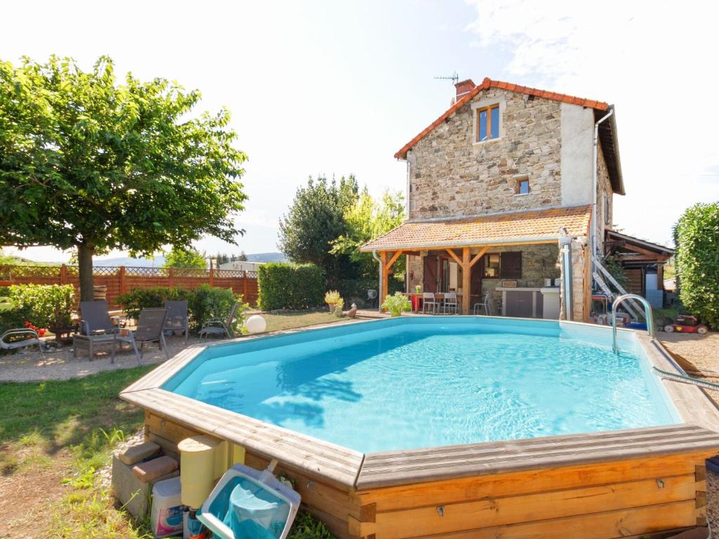 a large swimming pool in front of a house at Countryside holiday home with pool in Renaison