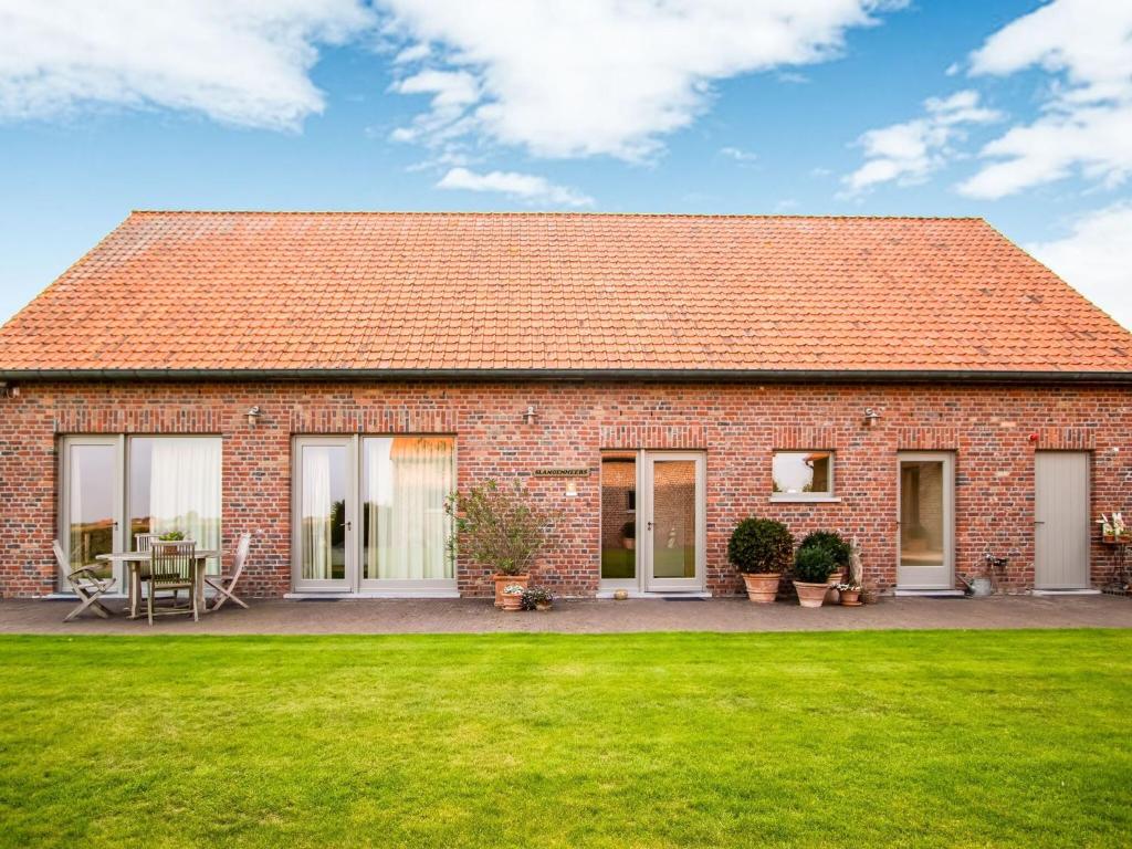 a red brick house with a green lawn at home in a rural setting with a wonderfully garden in Beselare
