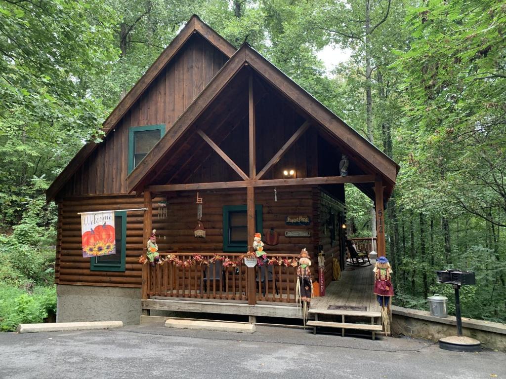 a log cabin in the woods with a porch at Forest Fling Cabin in McCookville