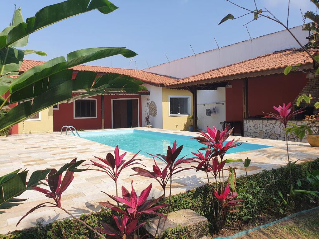 a swimming pool in front of a house at Casa Praia Itanhaém in Itanhaém