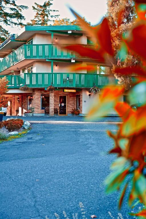 维多利亚Robin Hood Inn and Suites的道路一侧设有绿色阳台的建筑