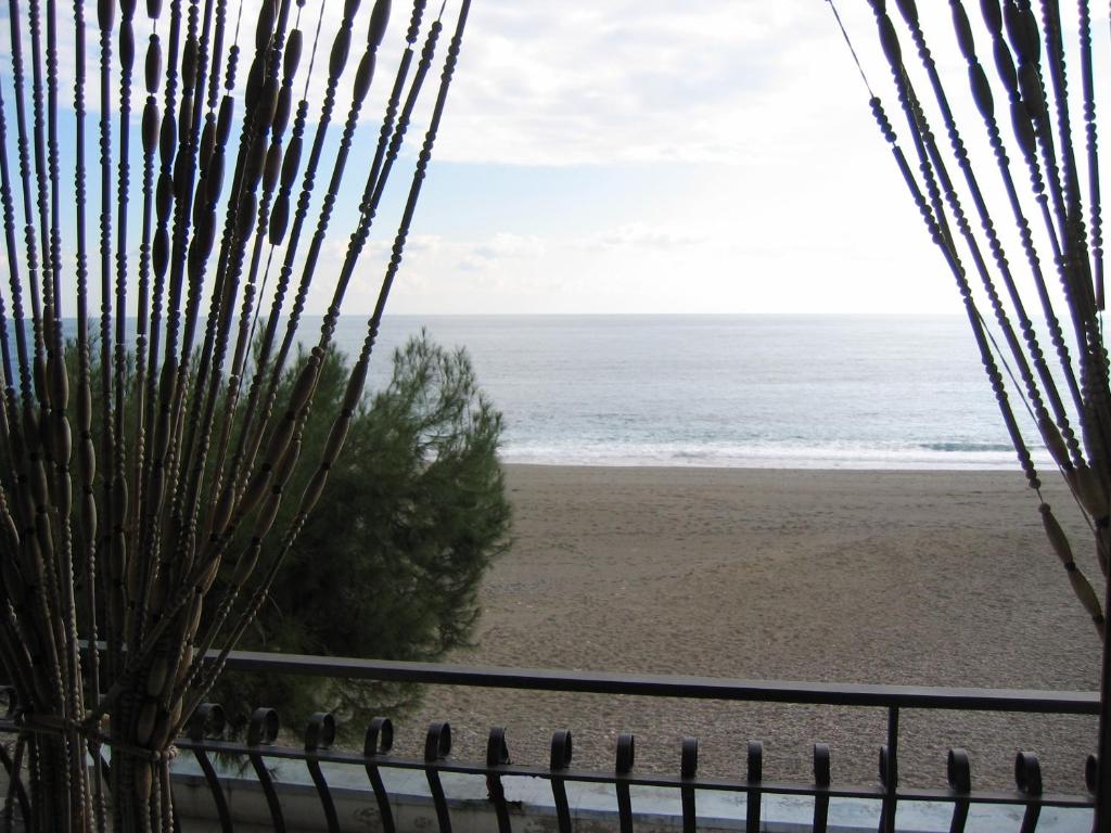 uma vista para a praia a partir de uma cerca em Casa del Sole em Letojanni