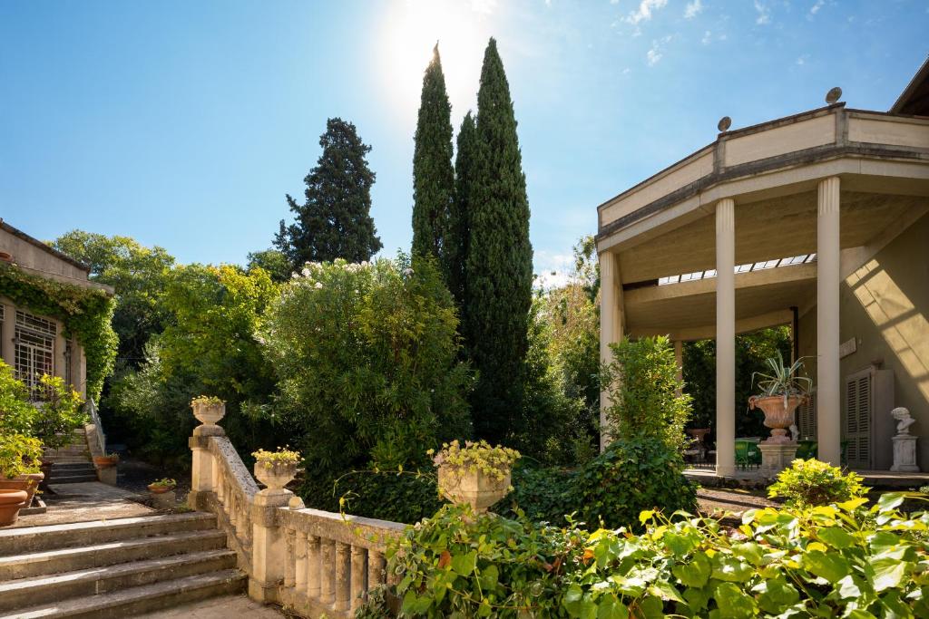 een huis met een hek en bomen en struiken bij Suite in Villa La Fenice in Monsummano