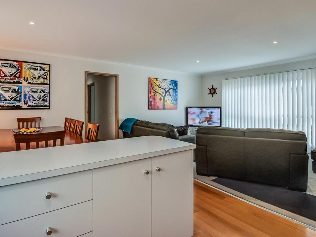 a living room with a couch and a flat screen tv at Colonnades in Cape Woolamai