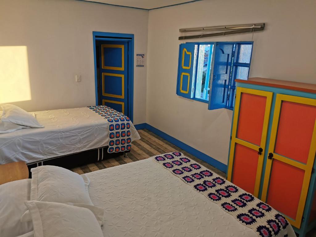 a bedroom with two beds and a colorful cabinet at Hotel Salento 1842 in Salento