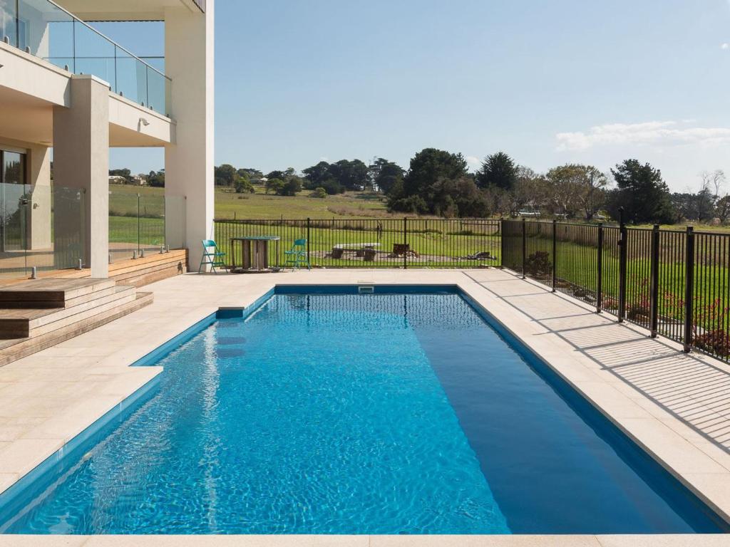 a swimming pool in front of a house at Ocean Breeze in San Remo