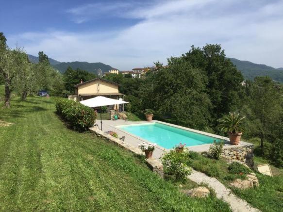 una piscina en un campo junto a una casa en CASA DELLA LUCE private pool, en Bagnone
