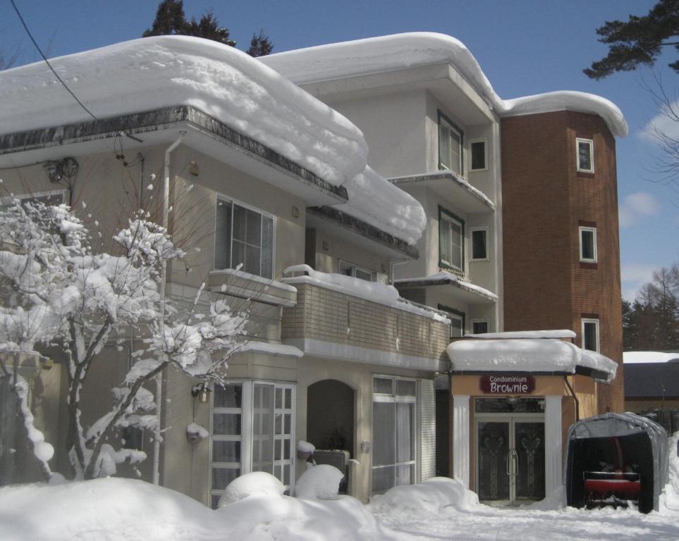 une maison avec de la neige au sommet dans l'établissement Hakuba Inn Bloom, à Hakuba
