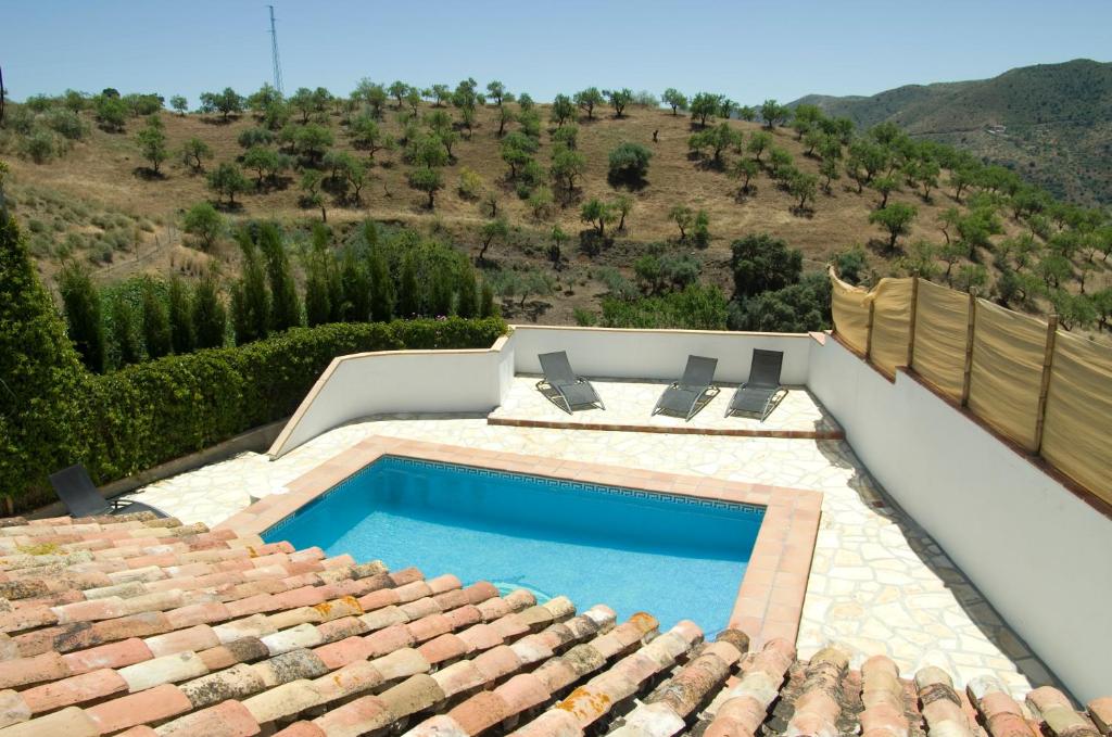 a swimming pool on the roof of a house at Rural Montes Málaga: Cortijo La Palma in Málaga