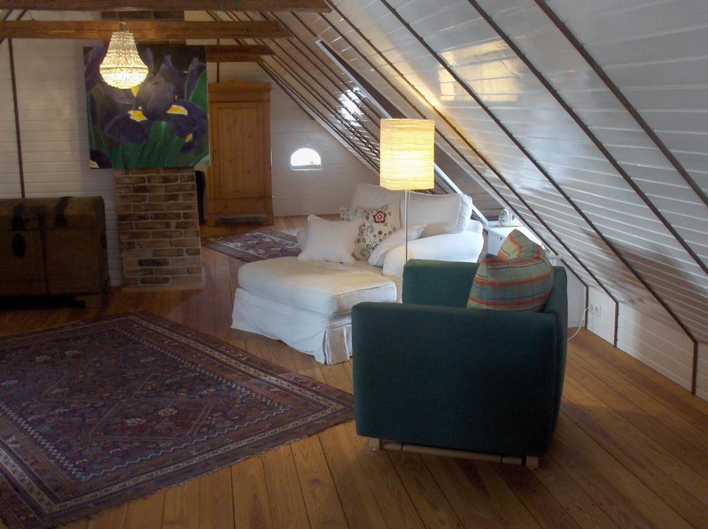 ein Wohnzimmer mit einem Sofa und einem Stuhl in der Unterkunft Das Reetdachhaus - Paulines Höft in Grömitz