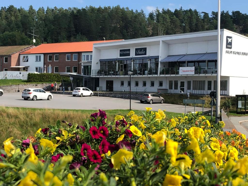 un edificio con coches estacionados en un estacionamiento en First Hotel Bengtsfors en Bengtsfors