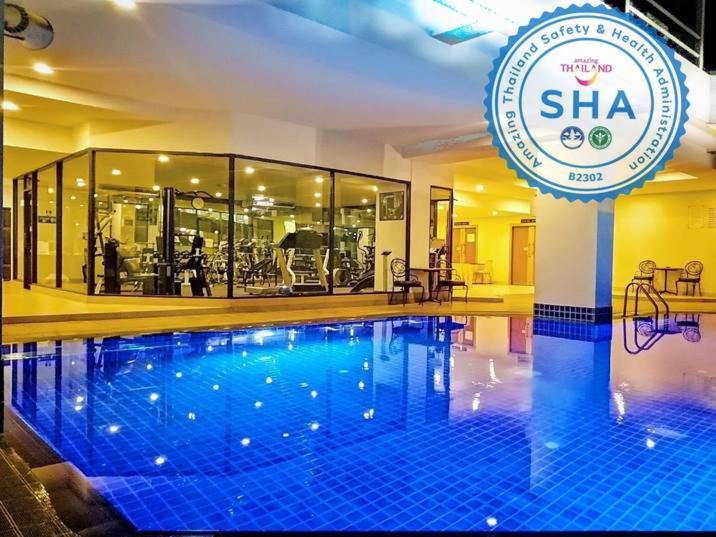 una piscina de hotel con un cartel delante en Tai Pan Hotel - SHA Plus Certified, en Bangkok