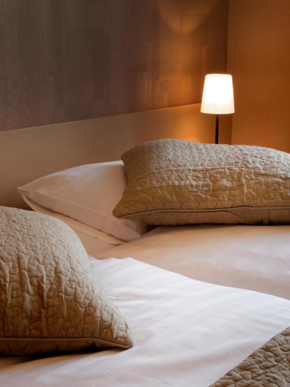 Uma cama ou camas num quarto em Hôtel la Suite