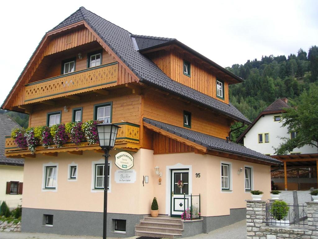 a large building with a wooden roof at Appartmenthaus Bachler in Haus im Ennstal