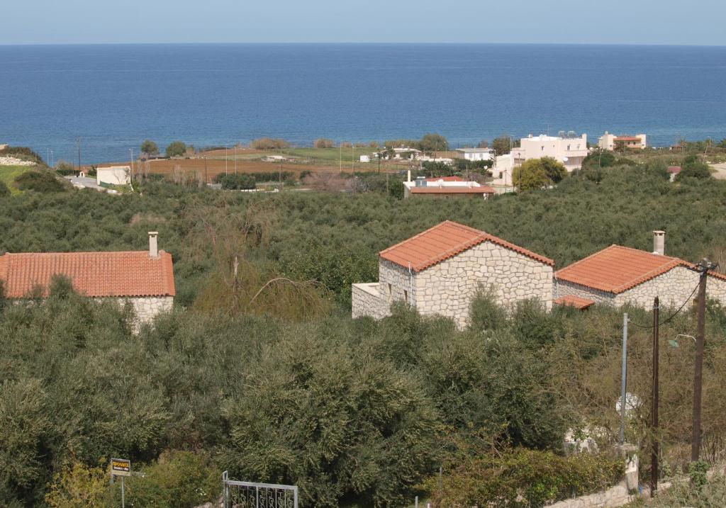 un grupo de casas en una colina cerca del océano en Gerolakos Country Houses, en Stavromenos
