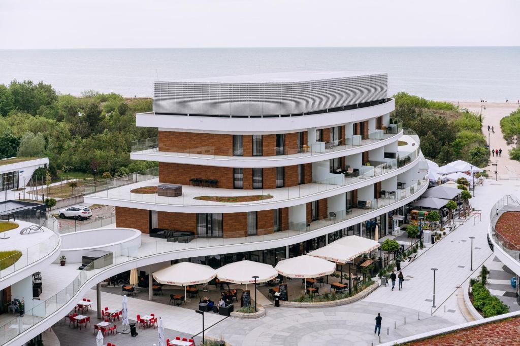 een uitzicht boven een gebouw met een strand op de achtergrond bij Baltic Park Molo Apartments by Zdrojowa in Świnoujście