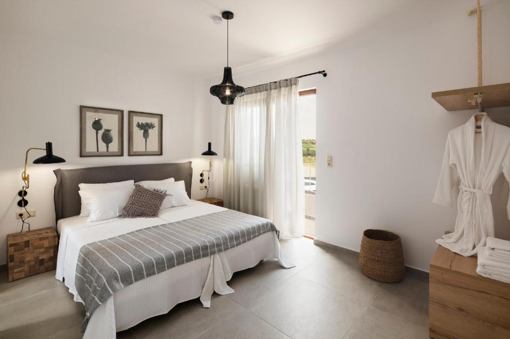 biała sypialnia z łóżkiem i oknem w obiekcie Zen Luxury Home, Family Sea Escape! w mieście Magnisía