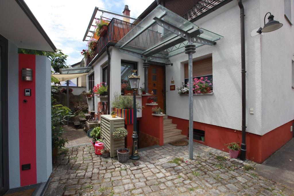 een huis met een rode deur en een balkon met bloemen bij Maison Marie in Ubstadt-Weiher