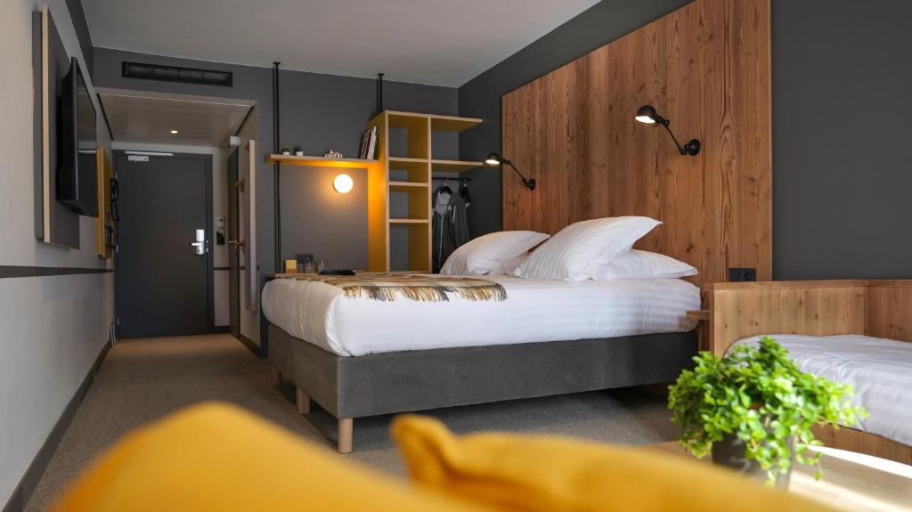 una camera d'albergo con due letti e una televisione di Plan B Hotel - Living Chamonix a Chamonix-Mont-Blanc