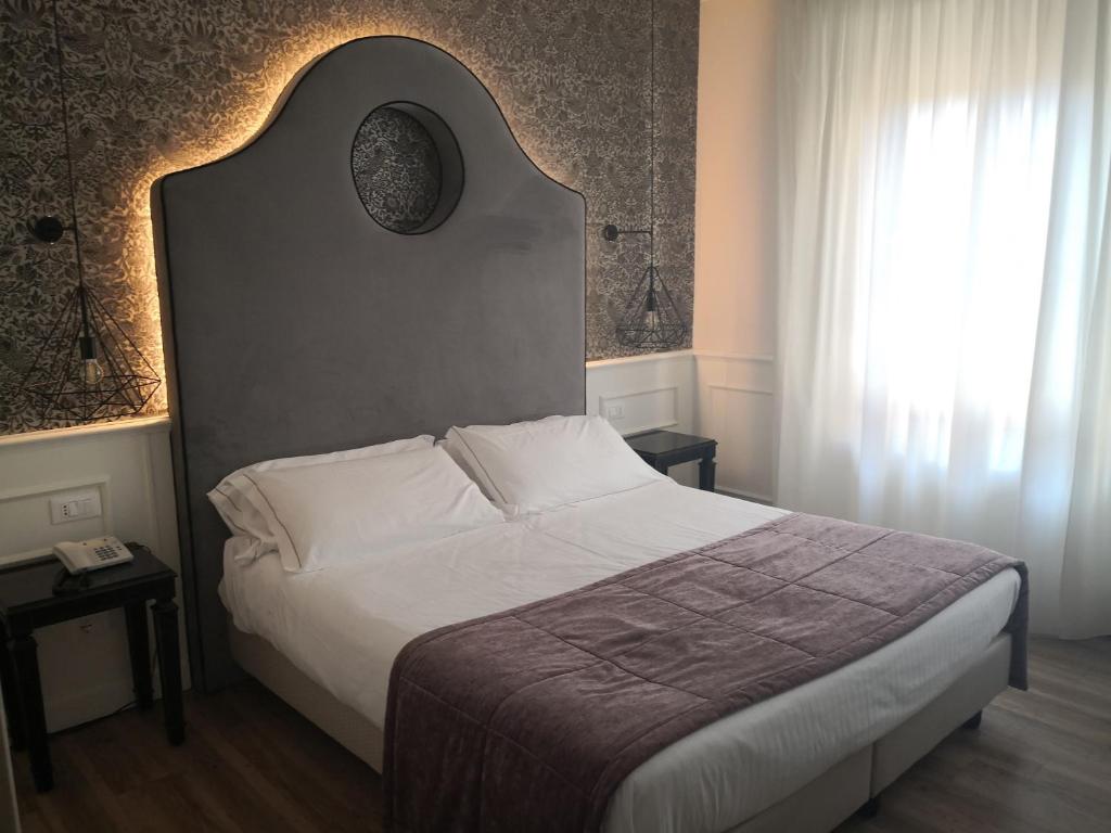 Un dormitorio con una cama grande y una ventana en Hotel San Luca, en Verona