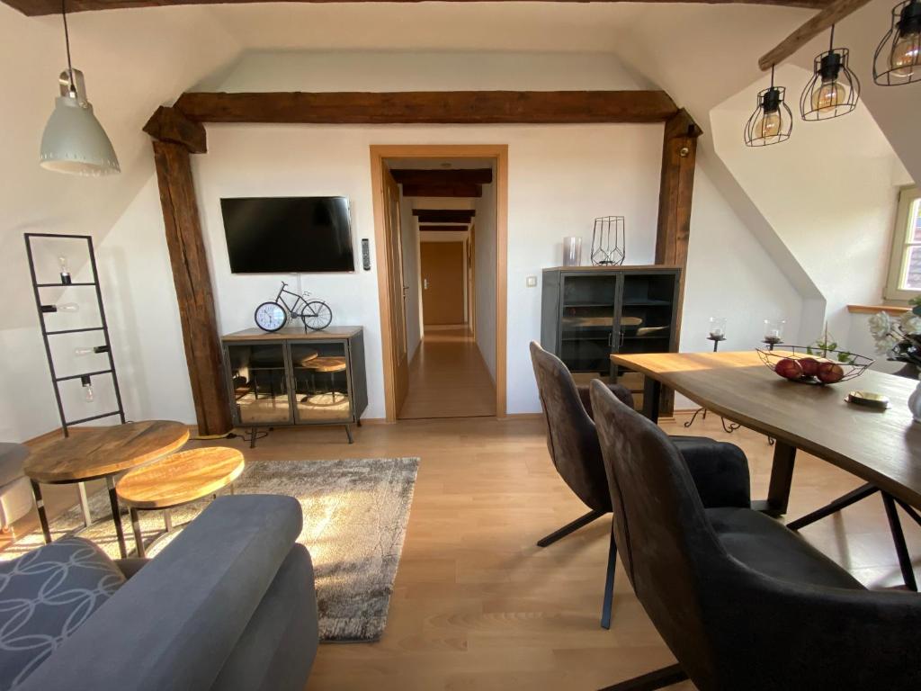 ein Wohnzimmer mit einem Tisch, Stühlen und einem TV in der Unterkunft Urlaub in der Welterbestadt Quedlinburg in Gernrode - Harz