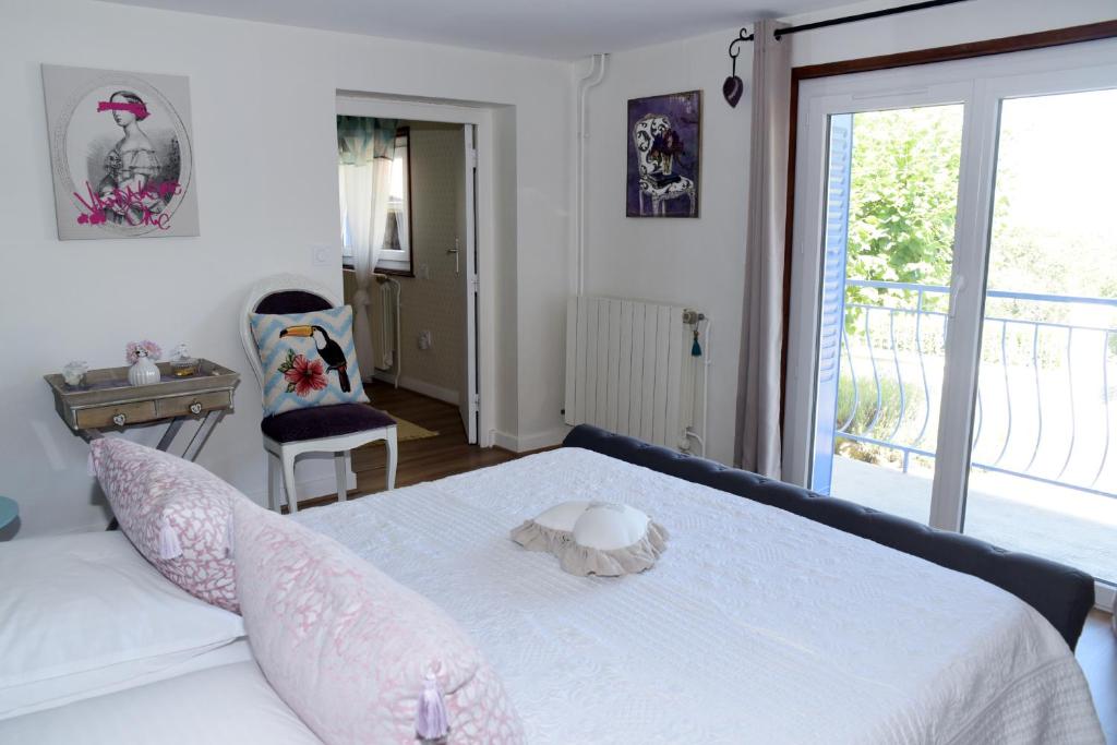 a bedroom with a white bed and a window at Les Bessonnes in Saint-Georges-Haute-Ville