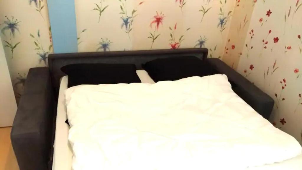łóżko w pokoju z białą pościelą w obiekcie Chambre privée dans maison centre-ville Sens Petit-déjeuner compris w mieście Sens