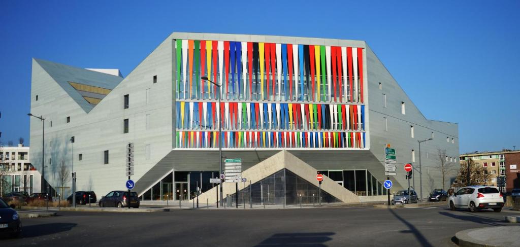 un bâtiment avec un grand bâtiment coloré dans l'établissement Auberge de Jeunesse HI Lille, à Lille