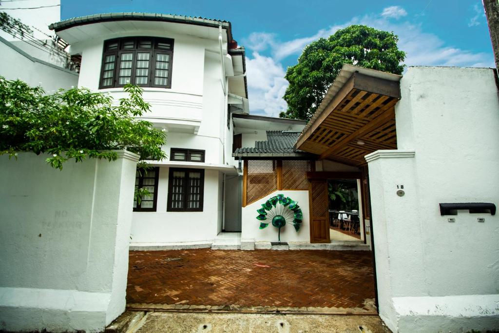 Uma casa branca com um portão à frente. em Lost & Found - Colombo em Colombo