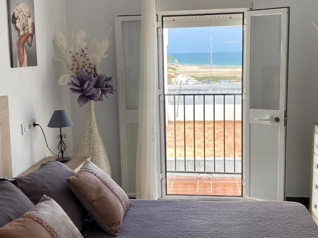 a bedroom with a bed and a view of the ocean at Piso en Conil con Vistas al mar in Conil de la Frontera