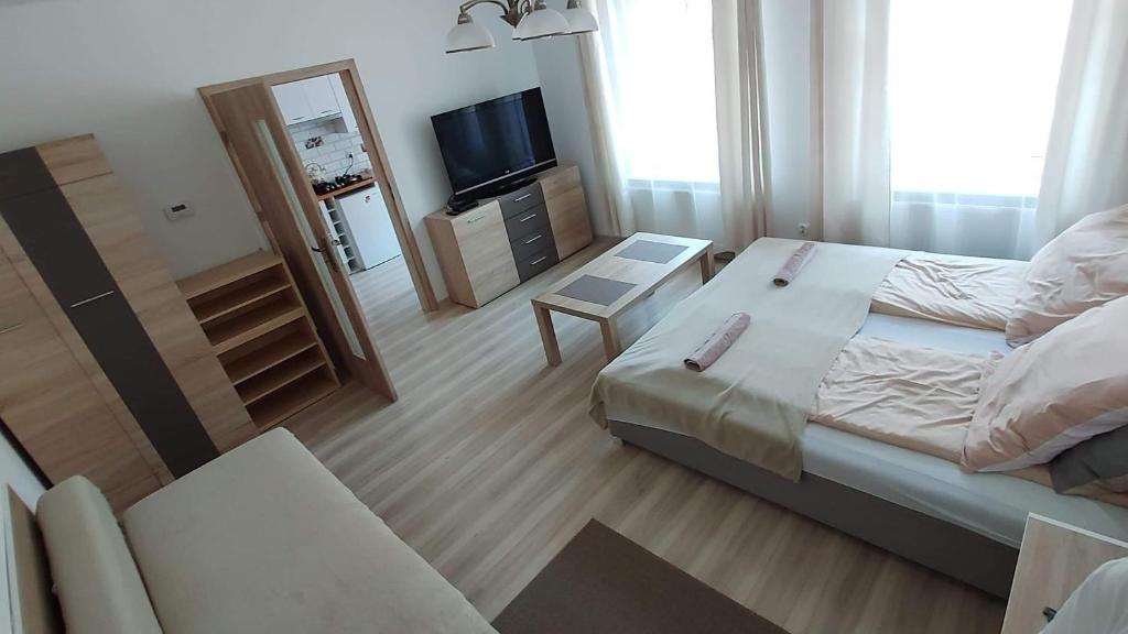 a small bedroom with a bed and a television at Stara Kamienica Centrum in Mrągowo