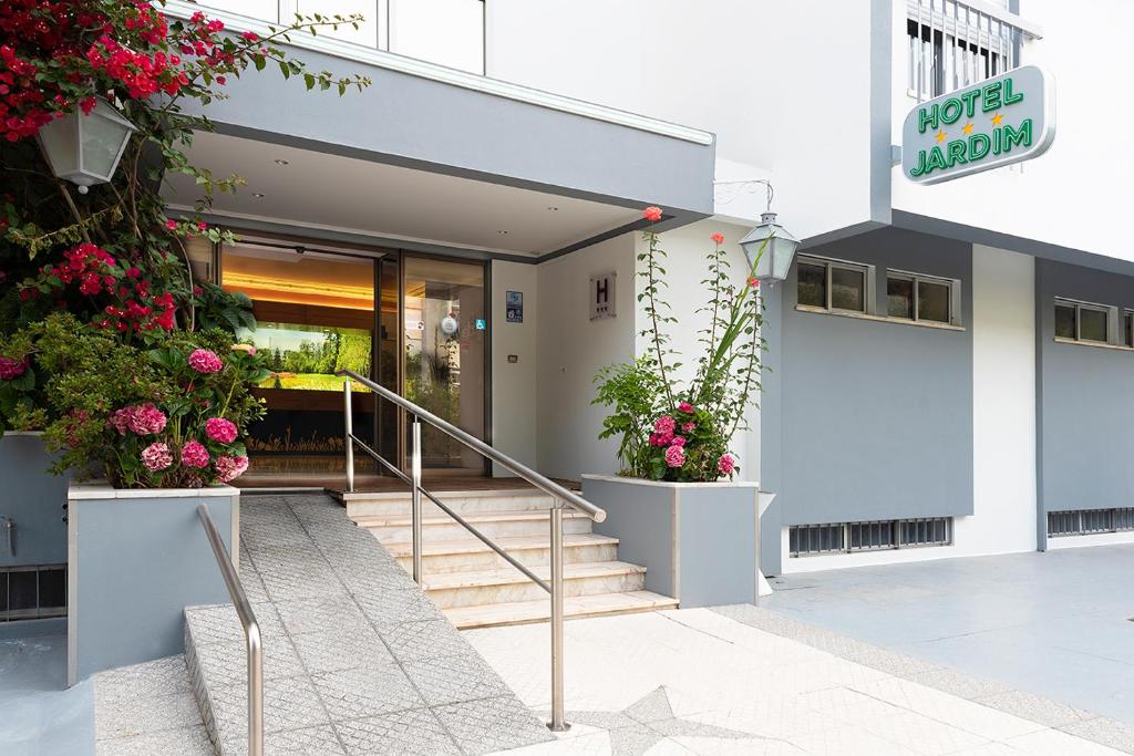 un bâtiment avec des fleurs en pots sur les escaliers dans l'établissement Hotel Jardim, à Aveiro