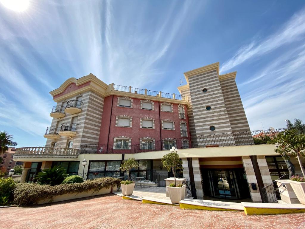 a large red building with trees in front of it at San Giovanni Rotondo Palace - Alihotels in San Giovanni Rotondo