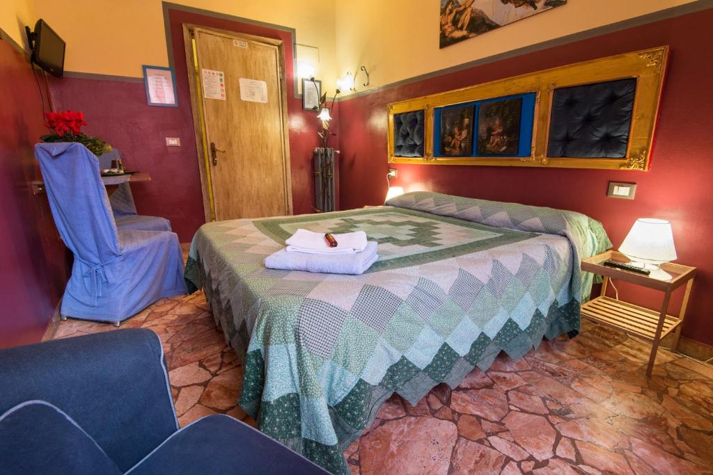 フィレンツェにあるジョルノ フォルテッツァ フィオレンティーナのベッドと椅子付きのホテルルーム