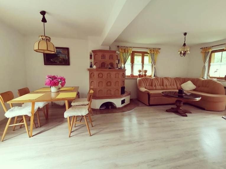 ein Wohnzimmer mit einem Sofa, einem Tisch und einem Kamin in der Unterkunft Chata Baračka in Omšenie