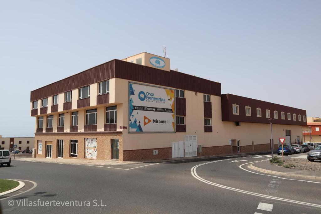 um edifício com um relógio na lateral em Edificio Prieto VIV 6 em Puerto del Rosario