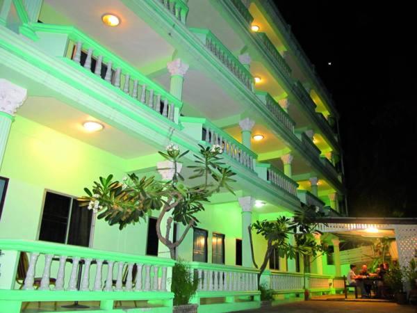 a large white building with green lights on it at NN Apartment in Pattaya South