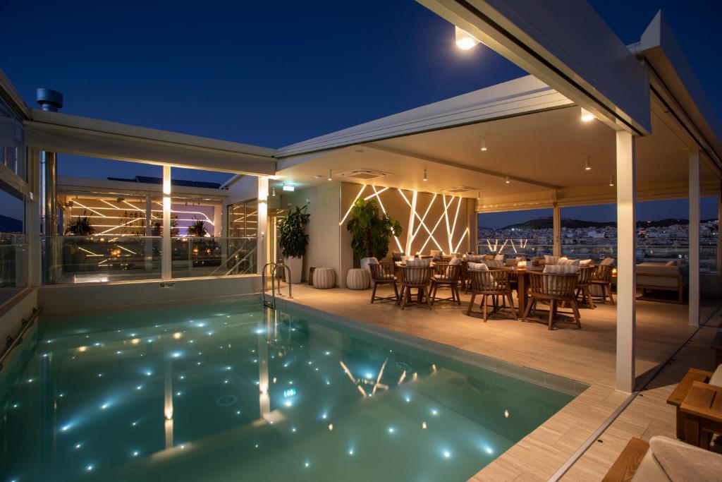 una casa con piscina por la noche en Green Suites Boutique Hotel, en Atenas