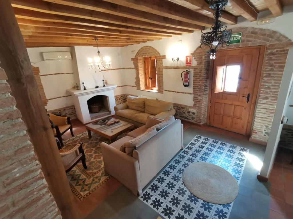 a living room with a couch and a fireplace at La Aldaba del siglo XX in Alcañizo