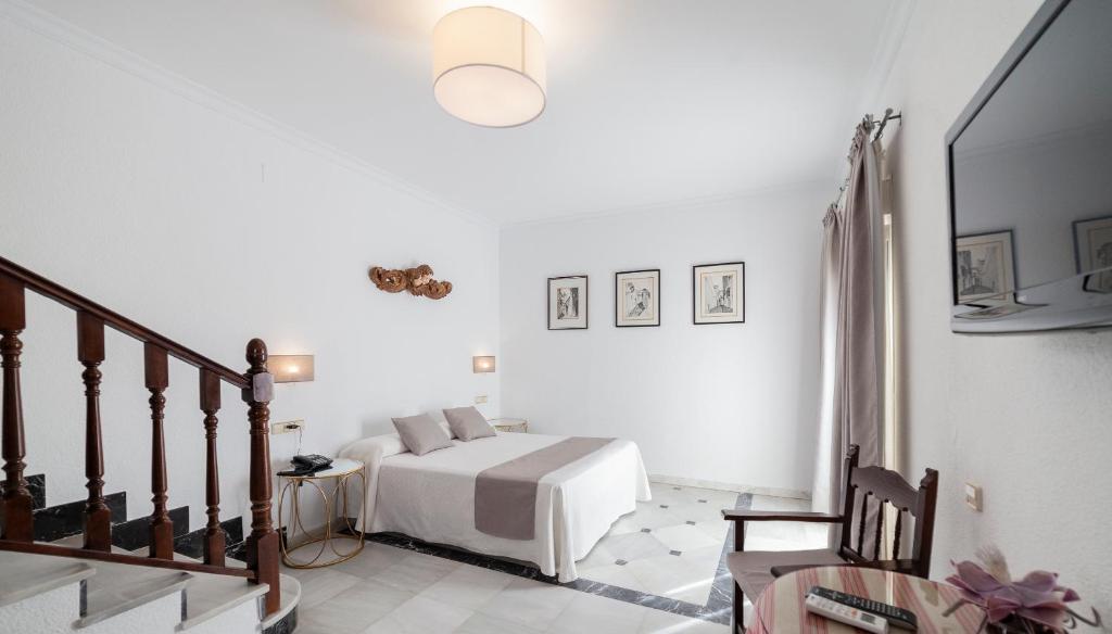 a bedroom with a bed and a lamp at Hotel El Convento in Arcos de la Frontera