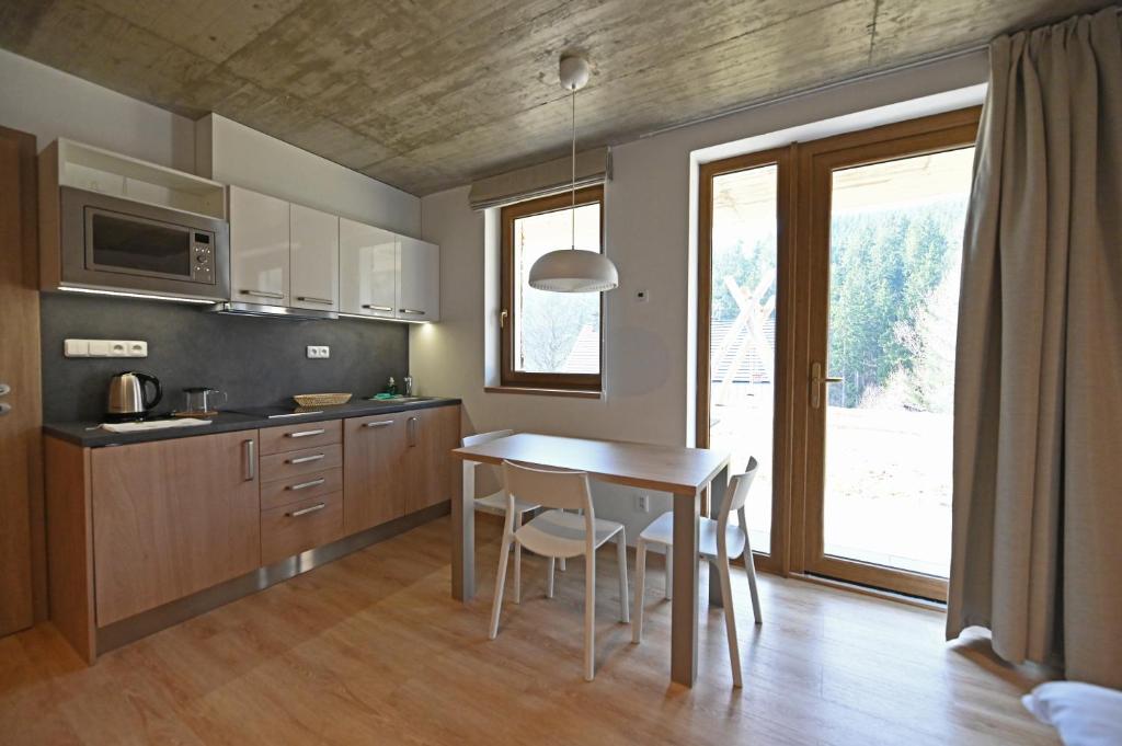 a kitchen with a table and chairs in a room at Vetrnik Depandance Hotelu Jirinka in Dolní Morava