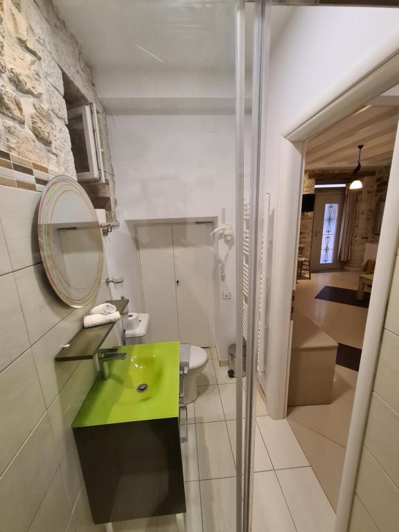 W łazience znajduje się zielona umywalka i lustro. w obiekcie NJ Corfu Liston Apartments w Korfu