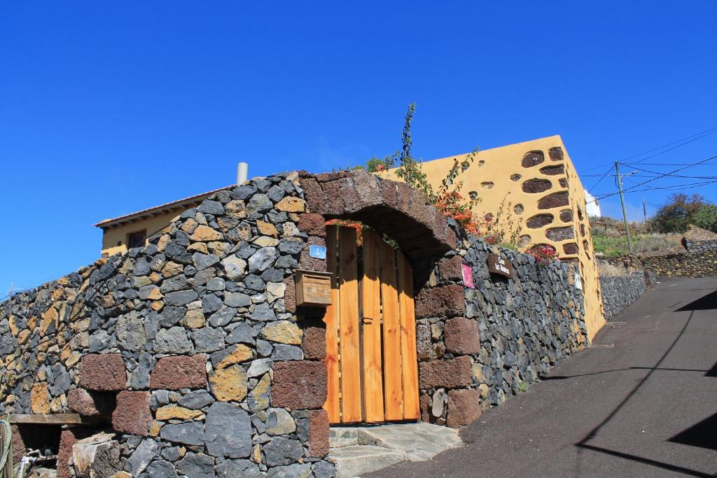 El Pinar del HierroにあるCasa los Abuelosの木の扉のある古い石造りの建物