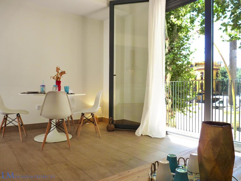 sala de estar con mesa, sillas y puerta corredera de cristal en ALAMEDA SQUARE APARTMENT, en Sevilla