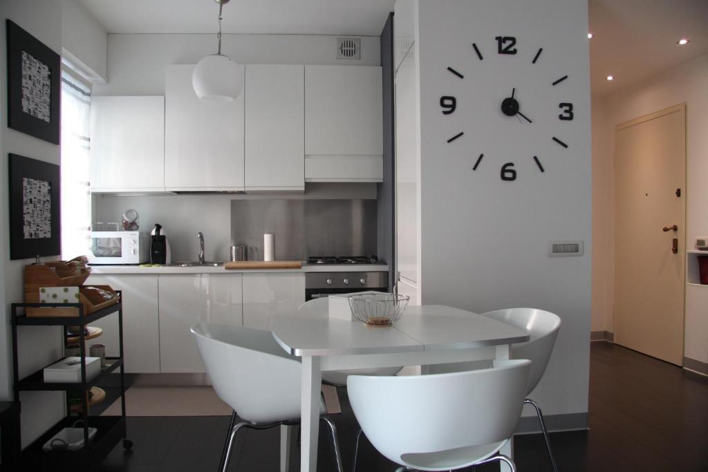 a kitchen with a table and a clock on the wall at Civico6 in Tirano