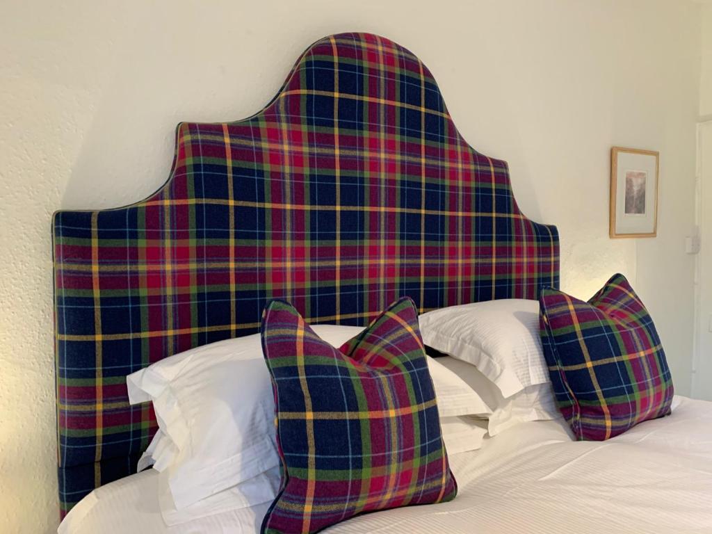 a plaid headboard on a bed with two pillows at High Street Flat in Sherborne