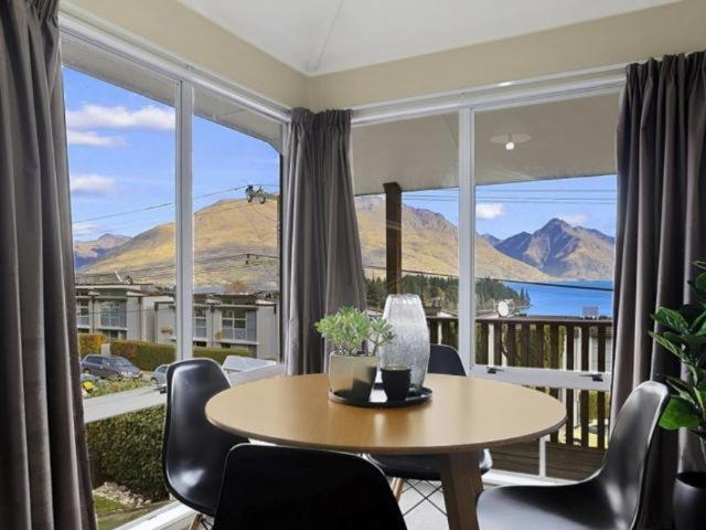 a table and chairs in a room with a large window at ULTIMATE CONVENIENCE, WALK-TO-TOWN TOWNHOUSE in Queenstown