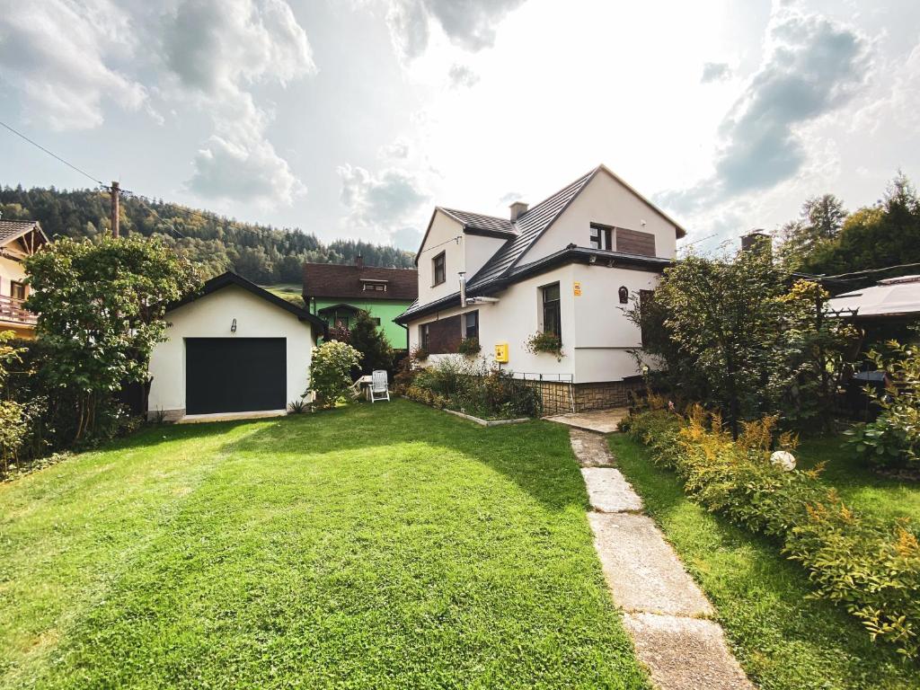 a yard with a white house and a house at Pokoje Gościnne u Renaty in Szczyrk